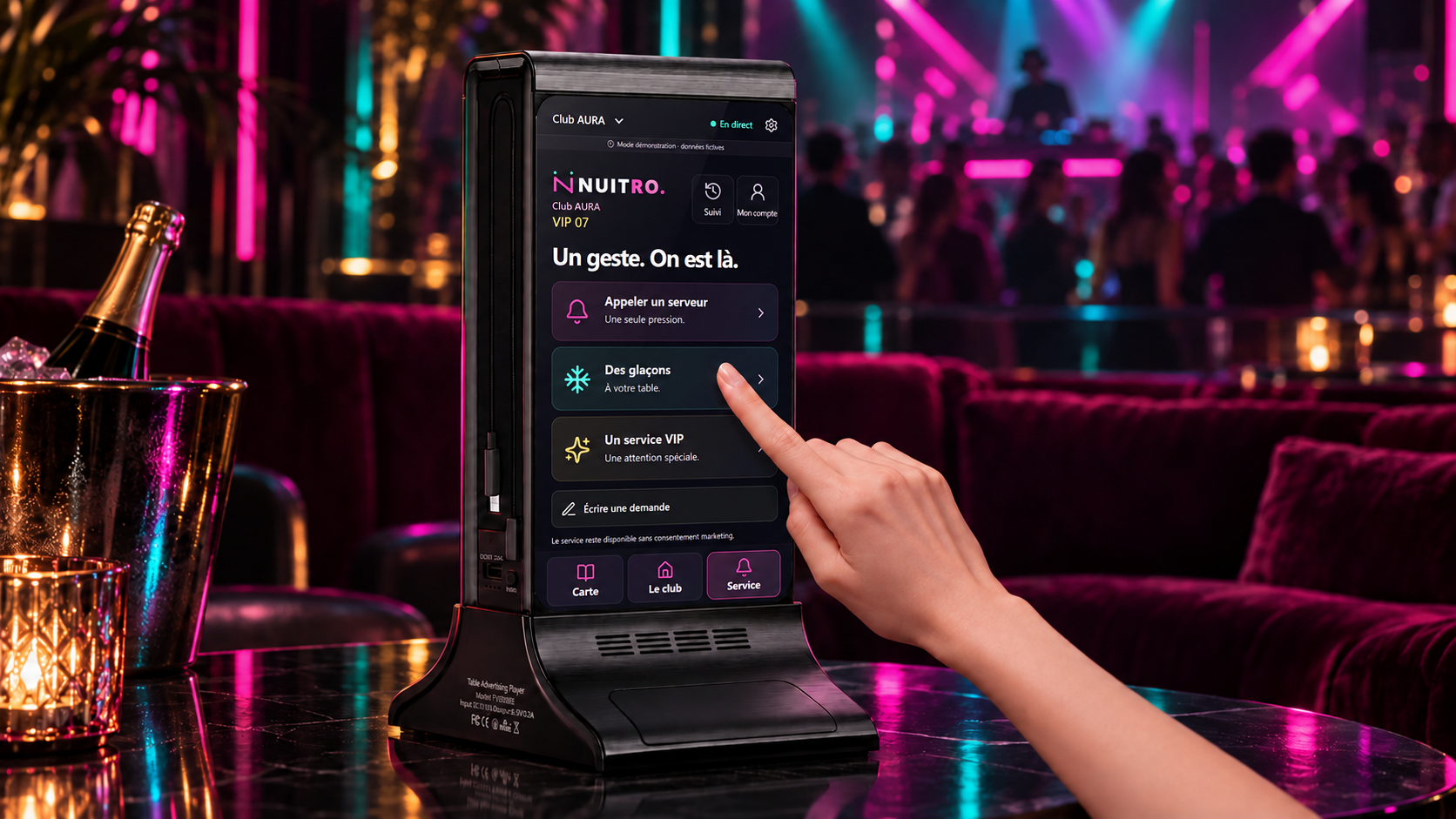 Mise en scène d’une borne noire FYD-835E sur une table dans une ambiance club magenta et menthe